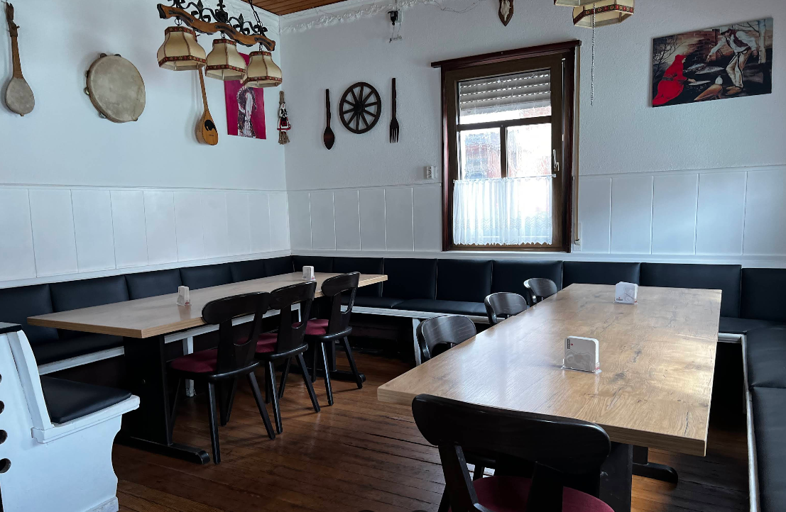 Heller Gastraum mit Holztischen bei Balkan Grill Genti